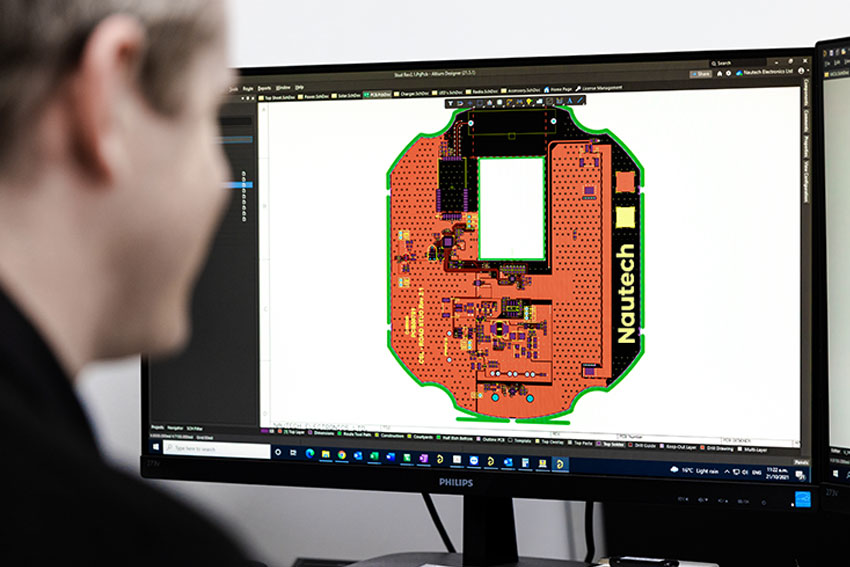 a man designing a circuit board on a computer